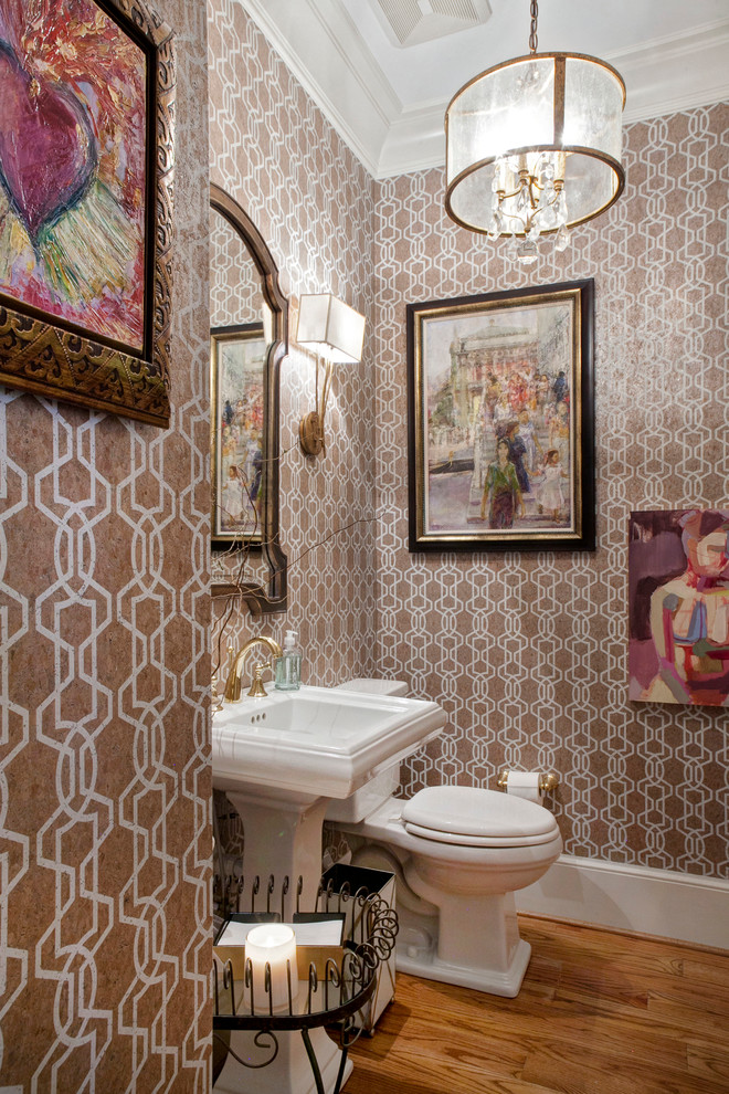 Mid-sized eclectic powder room in Other with a pedestal sink, a two-piece toilet and medium hardwood floors.