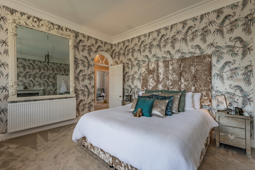 Großes Klassisches Hauptschlafzimmer mit bunten Wänden, Teppichboden, Kamin, Kaminumrandung aus Stein, grauem Boden und Tapetenwänden in Dorset