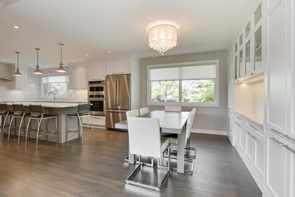 Kitchen/dining room combo - mid-sized transitional medium tone wood floor kitchen/dining room combo idea in Calgary with white walls, a corner fireplace and a stone fireplace