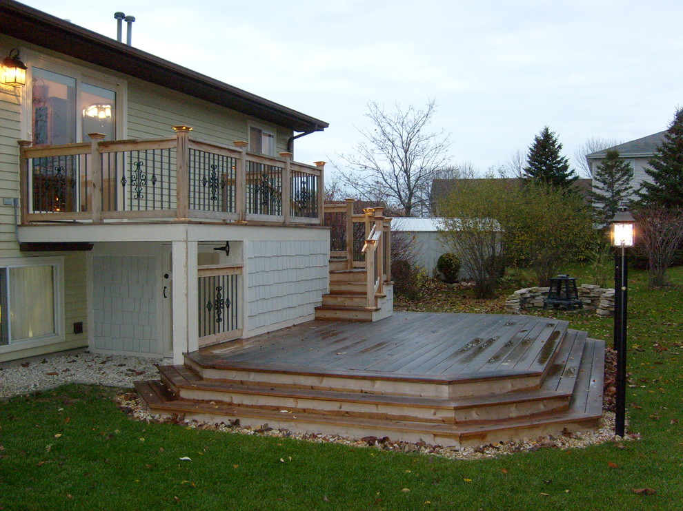 Example of a mid-sized beach style backyard deck design in Milwaukee with no cover
