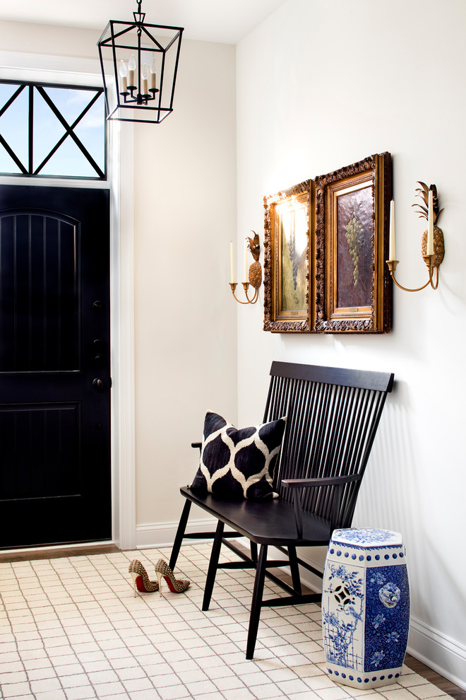 This is an example of a transitional foyer in Baltimore with white walls, a single front door and a black front door.