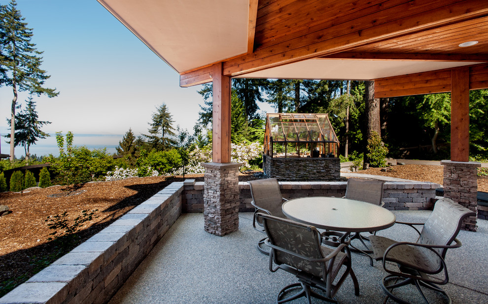 Large transitional backyard patio in Seattle with a vegetable garden, concrete pavers and a roof extension.