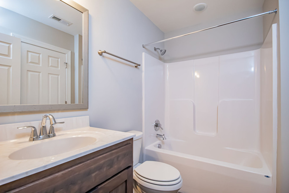 Inspiration for a mid-sized traditional kids bathroom in Richmond with flat-panel cabinets, brown cabinets, an alcove tub, a shower/bathtub combo, a two-piece toilet, grey walls, ceramic floors, an integrated sink, solid surface benchtops, grey floor, a shower curtain, white benchtops, a single vanity and a built-in vanity.