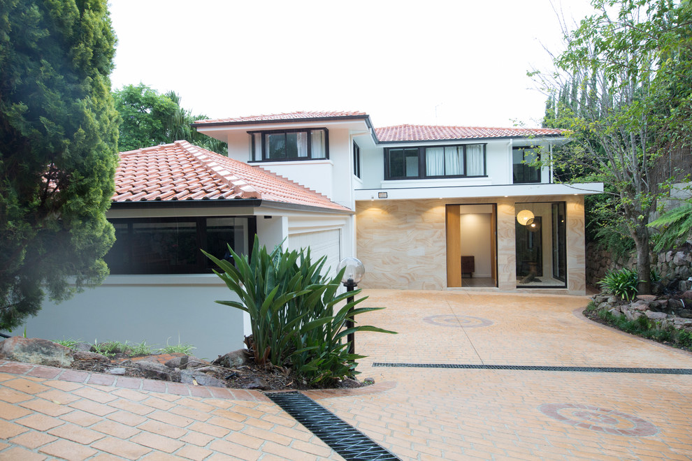 Photo of a contemporary two-storey white house exterior in Sydney with mixed siding, a hip roof and a tile roof.