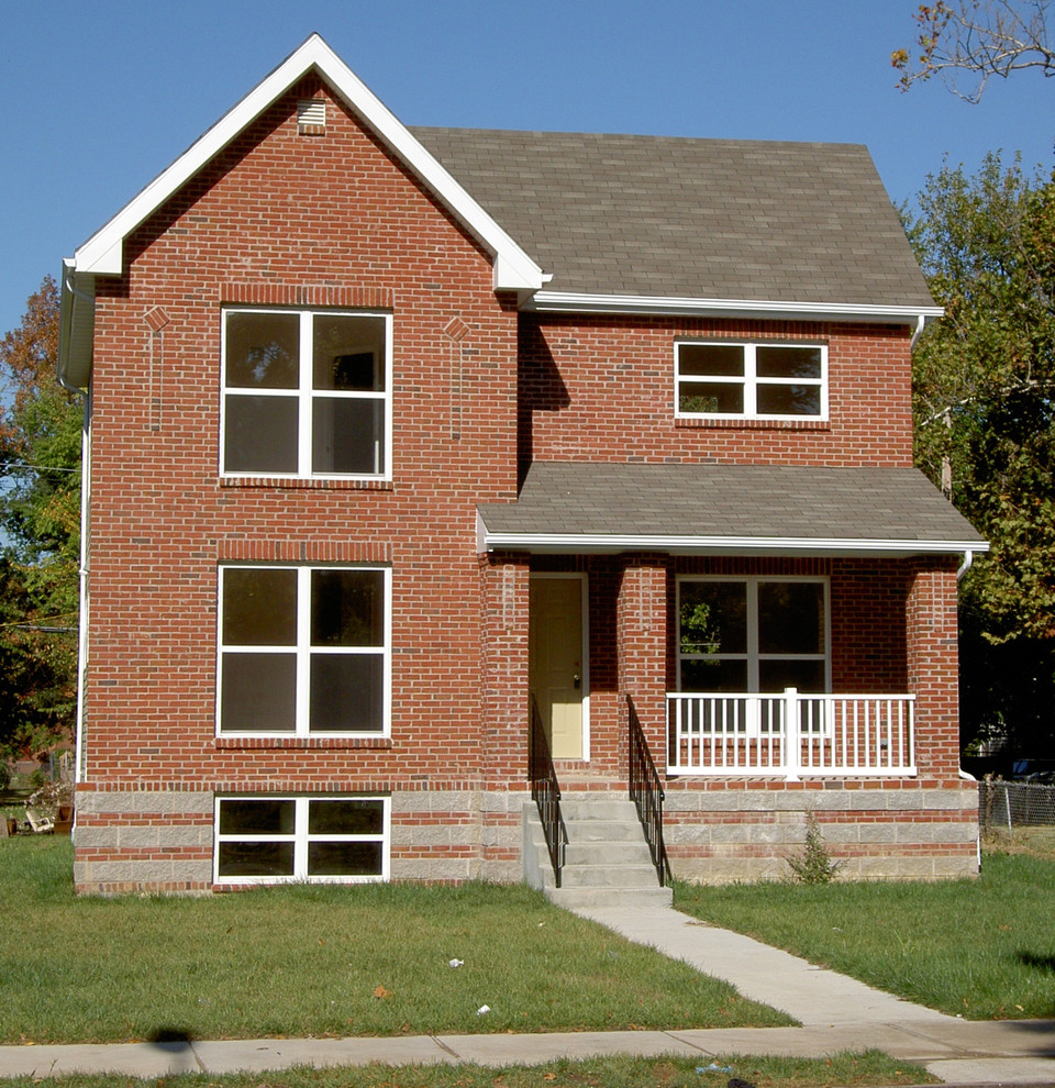 This is an example of a small traditional two-storey brick red exterior in St Louis with a gable roof.