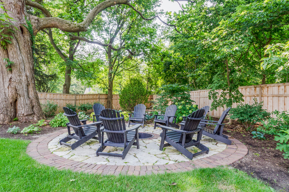 Large traditional backyard patio in Chicago with brick pavers and no cover.