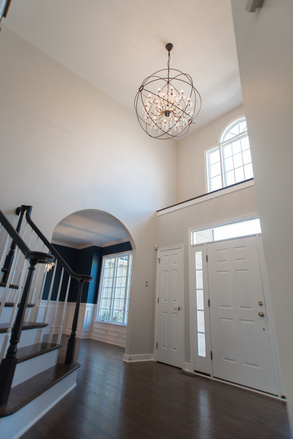 Foyer - large transitional medium tone wood floor and brown floor foyer idea in Baltimore with beige walls and a white front door