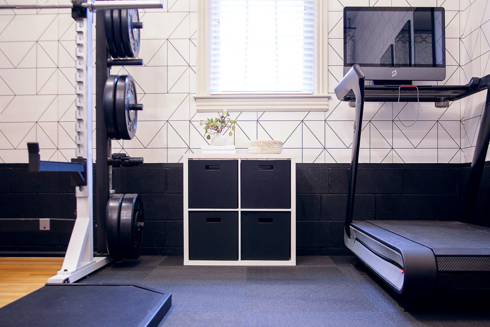 Mid-sized modern home weight room in Nashville with black floor.