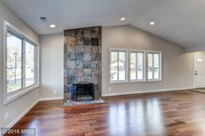 Inspiration for a mid-sized traditional formal enclosed living room in DC Metro with grey walls, medium hardwood floors, a standard fireplace, a tile fireplace surround, no tv and brown floor.