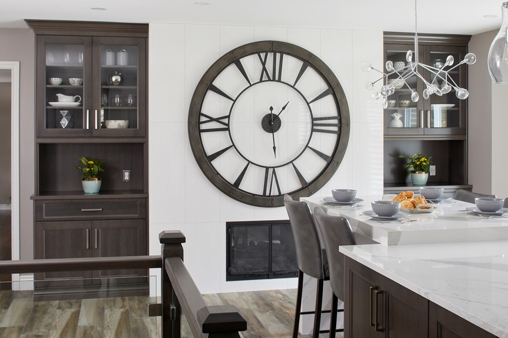 Example of a mid-sized transitional l-shaped light wood floor and multicolored floor eat-in kitchen design in Toronto with a farmhouse sink, shaker cabinets, dark wood cabinets, granite countertops, gray backsplash, stainless steel appliances, an island and white countertops