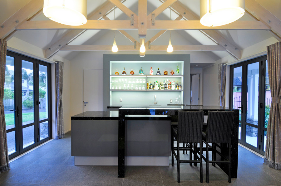 Contemporary galley seated home bar in Auckland with an undermount sink, grey cabinets, marble benchtops, blue splashback, glass sheet splashback and ceramic floors.