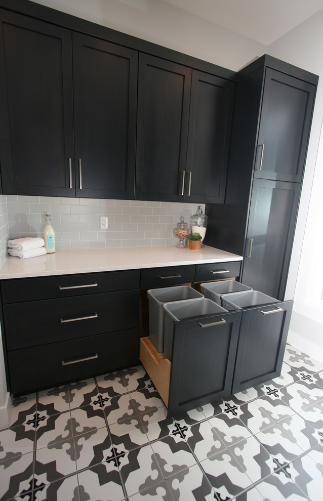 Mid-sized contemporary galley dedicated laundry room in Seattle with an undermount sink, shaker cabinets, black cabinets, quartz benchtops, grey walls, ceramic floors, a side-by-side washer and dryer, multi-coloured floor and white benchtop.
