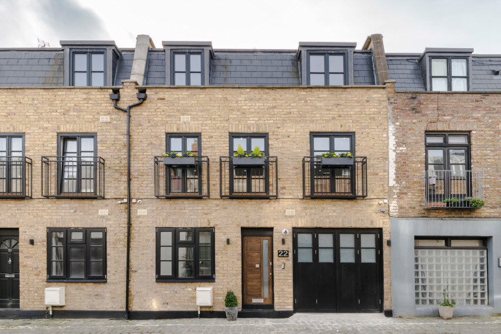 Kleines, Dreistöckiges Modernes Reihenhaus mit Backsteinfassade, beiger Fassadenfarbe, Mansardendach, Schindeldach und schwarzem Dach in London