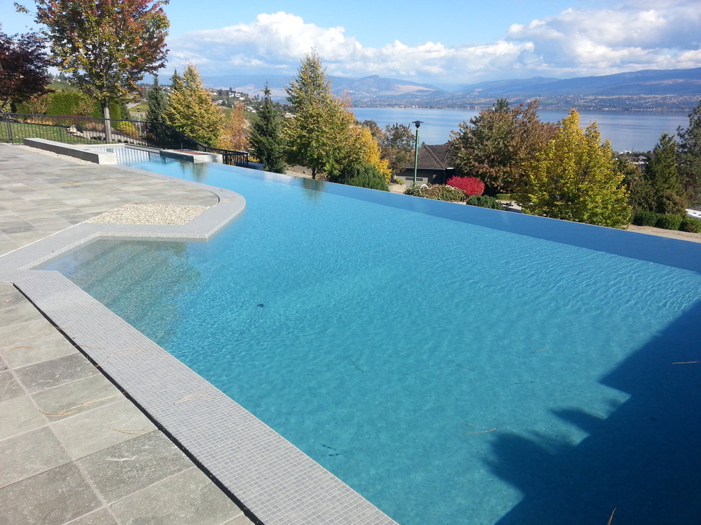 Design ideas for a large modern front yard l-shaped lap pool in Vancouver with tile.