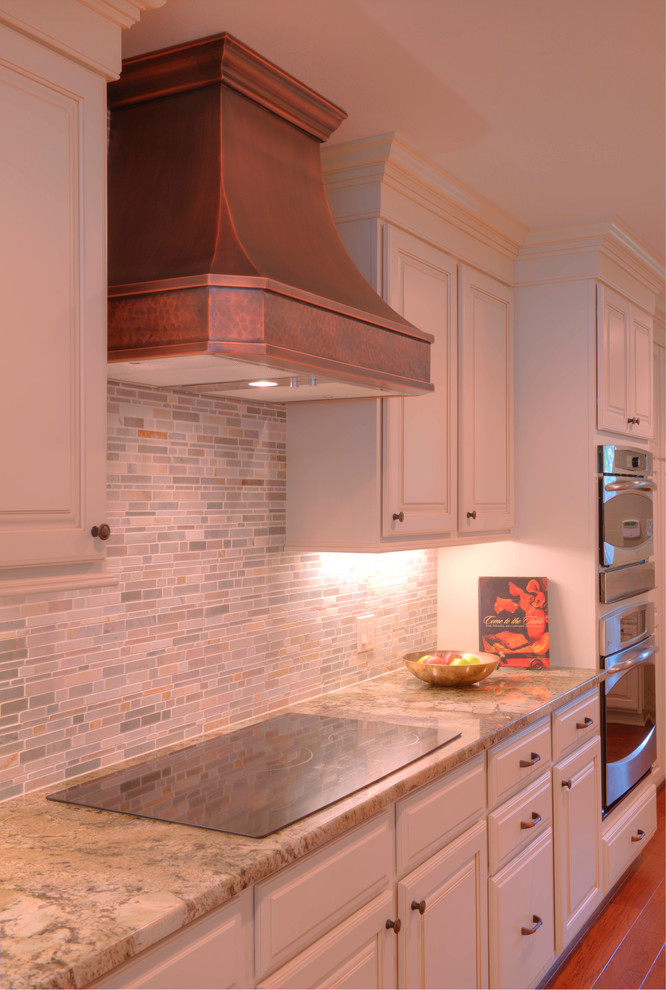 Transitional galley open concept kitchen photo in New Orleans with an undermount sink, raised-panel cabinets, white cabinets, granite countertops, gray backsplash, mirror backsplash, stainless steel appliances, engineered wood floors and a peninsula