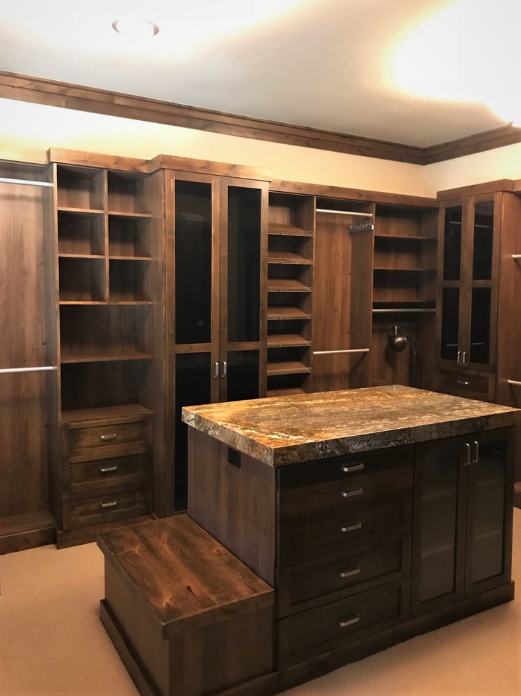 Photo of a large traditional gender-neutral walk-in wardrobe in Salt Lake City with shaker cabinets, dark wood cabinets, carpet and beige floor.