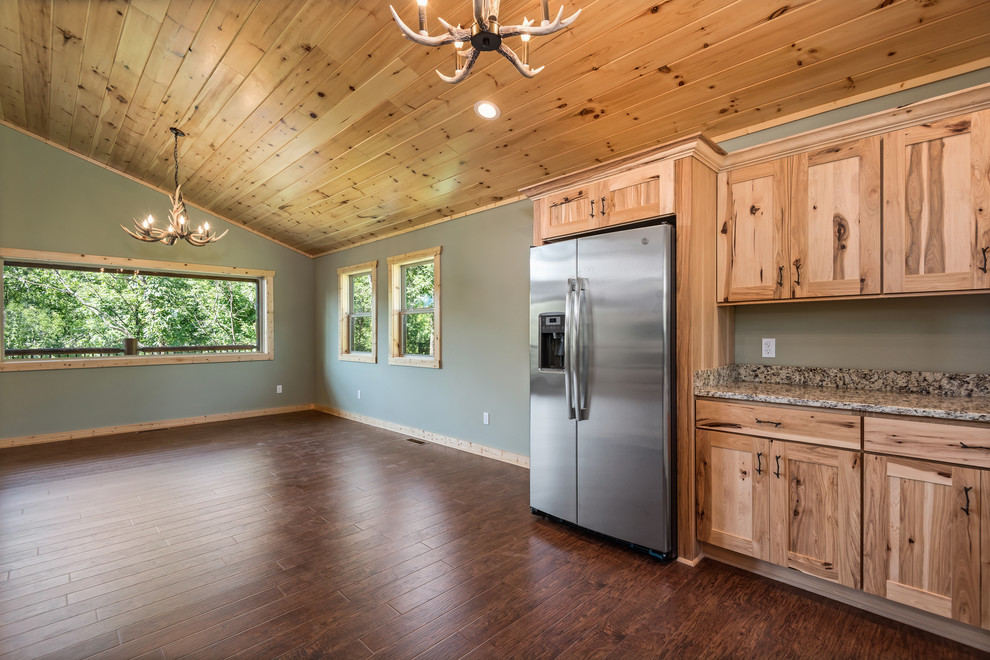 Large mountain style u-shaped laminate floor and brown floor eat-in kitchen photo with a double-bowl sink, recessed-panel cabinets, light wood cabinets, granite countertops, multicolored backsplash, stainless steel appliances, no island and multicolored countertops