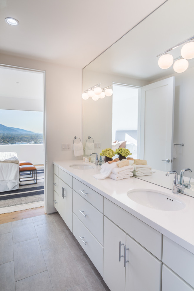 Large contemporary master bathroom in Los Angeles with flat-panel cabinets, white cabinets, a one-piece toilet, white walls, porcelain floors, an undermount sink, solid surface benchtops, grey floor, white benchtops, a double vanity and a built-in vanity.
