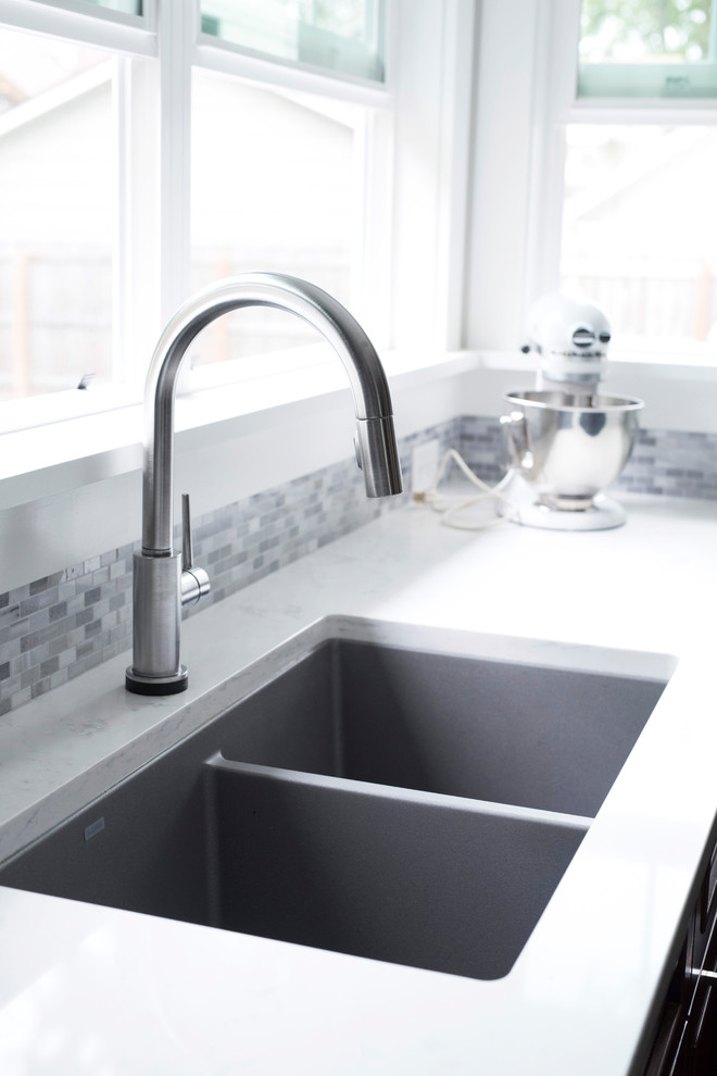 Inspiration for a mid-sized transitional u-shaped vinyl floor and multicolored floor kitchen remodel with an undermount sink, shaker cabinets, brown cabinets, quartz countertops, gray backsplash, marble backsplash, stainless steel appliances, no island and white countertops