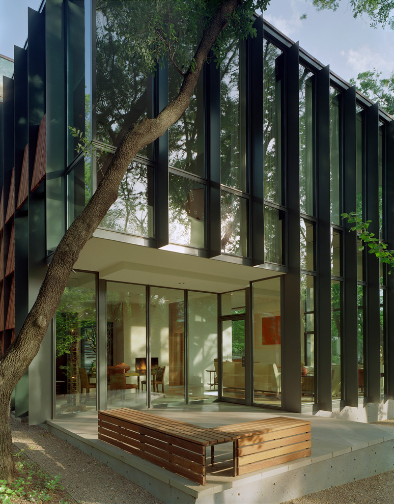 Design ideas for a contemporary two-storey glass exterior in Dallas.
