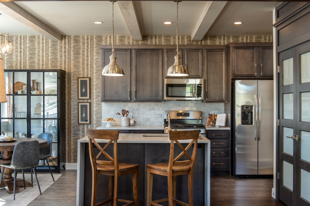 Transitional eat-in kitchen in Salt Lake City with an undermount sink, recessed-panel cabinets, dark wood cabinets, grey splashback, stainless steel appliances, dark hardwood floors, with island, brown floor, quartzite benchtops, marble splashback and white benchtop.