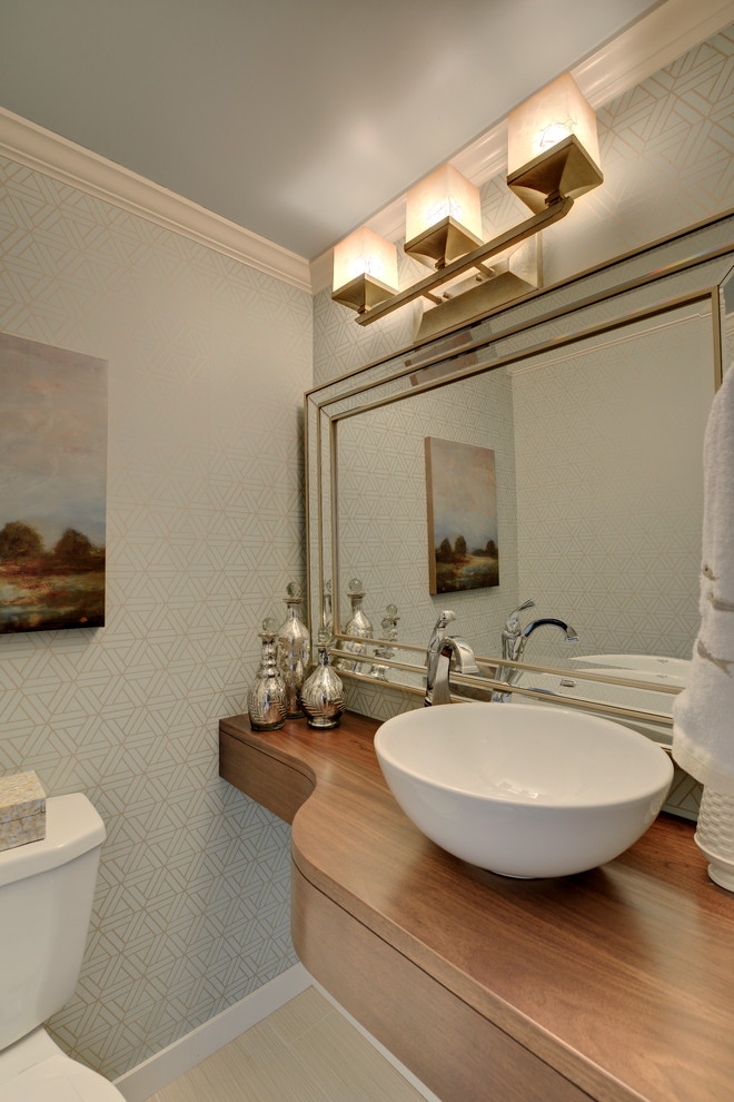 This is an example of a small transitional powder room in Phoenix with a vessel sink, wood benchtops, a two-piece toilet, beige tile, ceramic tile, blue walls, open cabinets, medium wood cabinets, bamboo floors, beige floor and brown benchtops.