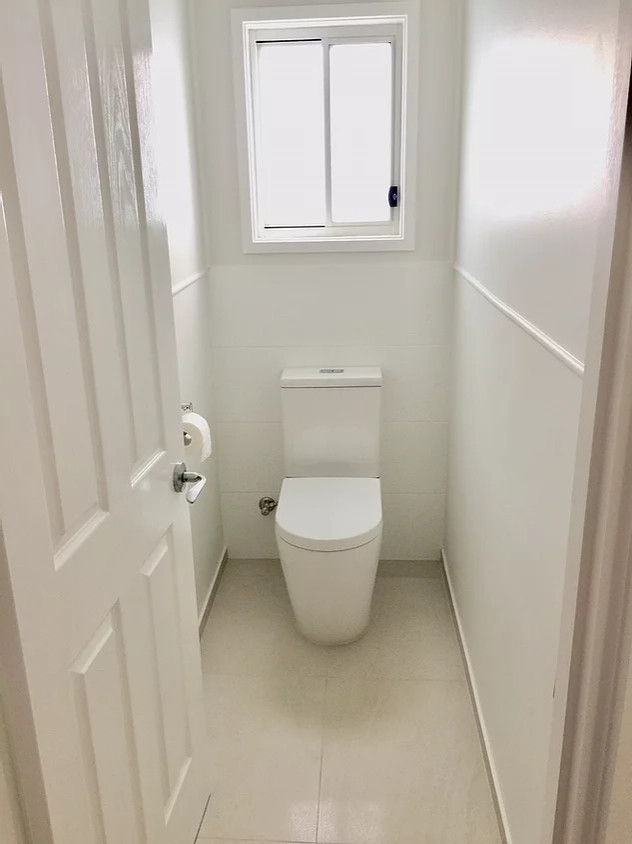 Idées déco pour un petit WC et toilettes victorien avec un placard en trompe-l'oeil, des portes de placard blanches, WC à poser, un carrelage blanc, des carreaux de porcelaine, un mur blanc, un sol en carrelage de porcelaine, un lavabo intégré, un plan de toilette en stratifié, un sol beige, un plan de toilette blanc et meuble-lavabo sur pied.
