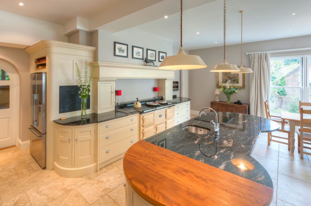 Photo of an expansive country open plan kitchen in Other with a farmhouse sink, shaker cabinets, grey cabinets, granite benchtops, black splashback, stone slab splashback, stainless steel appliances, travertine floors and with island.