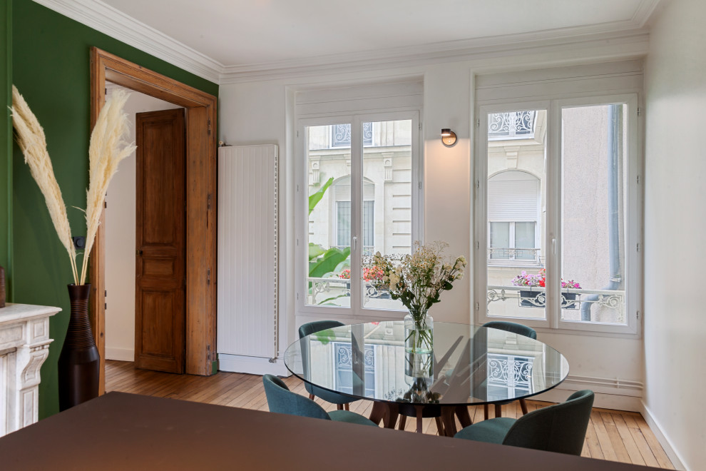 Cette photo montre une salle de séjour chic de taille moyenne et ouverte avec un mur vert, parquet clair, une cheminée standard et un manteau de cheminée en pierre.