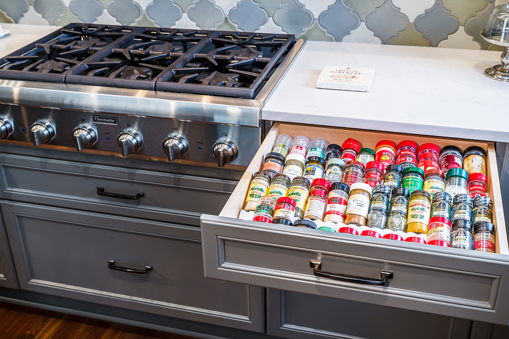 Mid-sized transitional l-shaped dark wood floor eat-in kitchen photo in Chicago with an undermount sink, recessed-panel cabinets, gray cabinets, granite countertops, multicolored backsplash, porcelain backsplash, paneled appliances and an island
