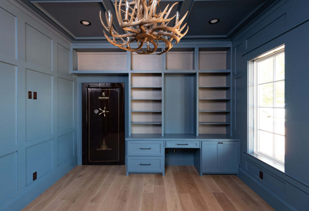 Design ideas for a mid-sized country study room in Dallas with blue walls, light hardwood floors, no fireplace, a freestanding desk, brown floor, coffered and panelled walls.