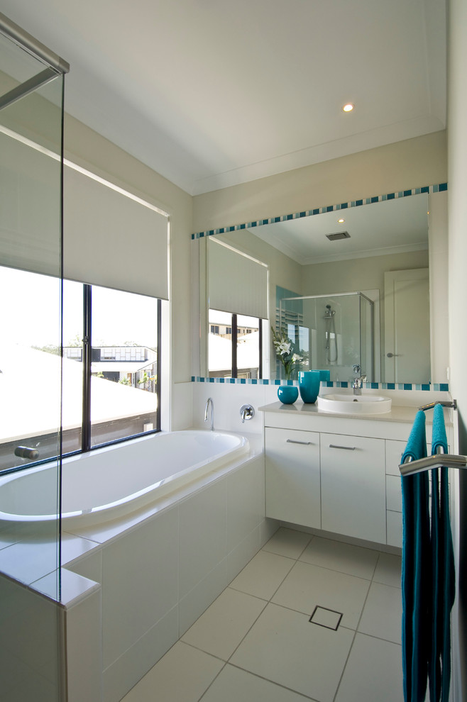 Inspiration for a mid-sized modern kids bathroom in Brisbane with a drop-in sink, flat-panel cabinets, white cabinets, engineered quartz benchtops, a corner shower, a two-piece toilet, white tile, terra-cotta tile, white walls, terra-cotta floors and a drop-in tub.