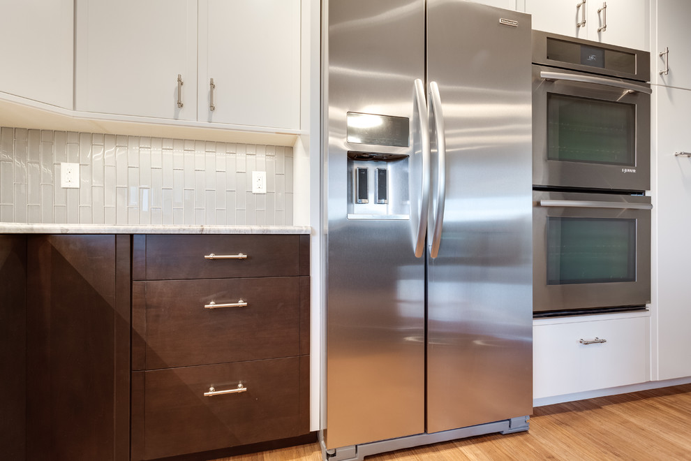 Contemporary u-shaped separate kitchen in DC Metro with an undermount sink, granite benchtops, glass tile splashback, stainless steel appliances, medium hardwood floors and with island.