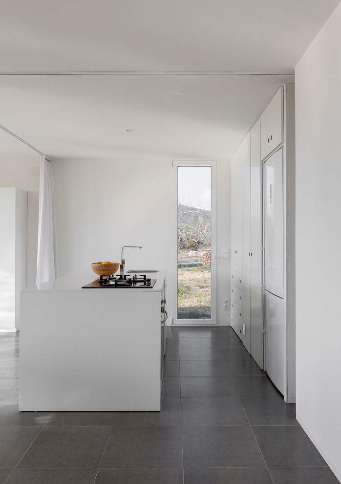 This is an example of a mid-sized contemporary single-wall open plan kitchen in Bilbao with flat-panel cabinets, white cabinets, ceramic floors and with island.