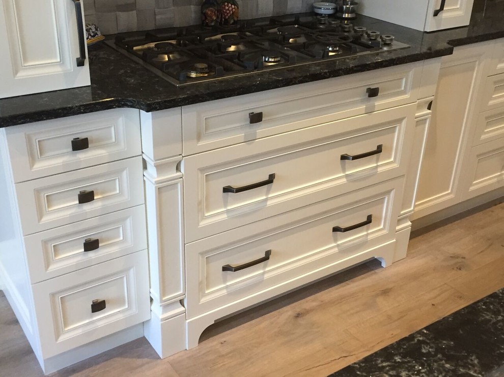 Kitchen - transitional light wood floor kitchen idea in Toronto with beaded inset cabinets, white cabinets and stainless steel appliances