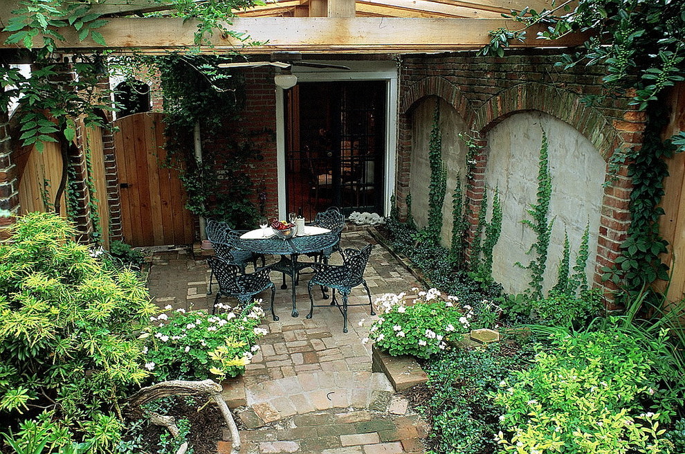 Design ideas for a small transitional backyard shaded garden for summer in DC Metro with brick pavers.
