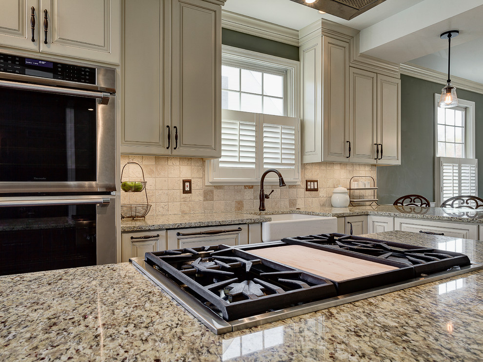Mountain style eat-in kitchen photo in Columbus with a farmhouse sink, flat-panel cabinets, white cabinets, marble countertops, beige backsplash, stone tile backsplash and stainless steel appliances