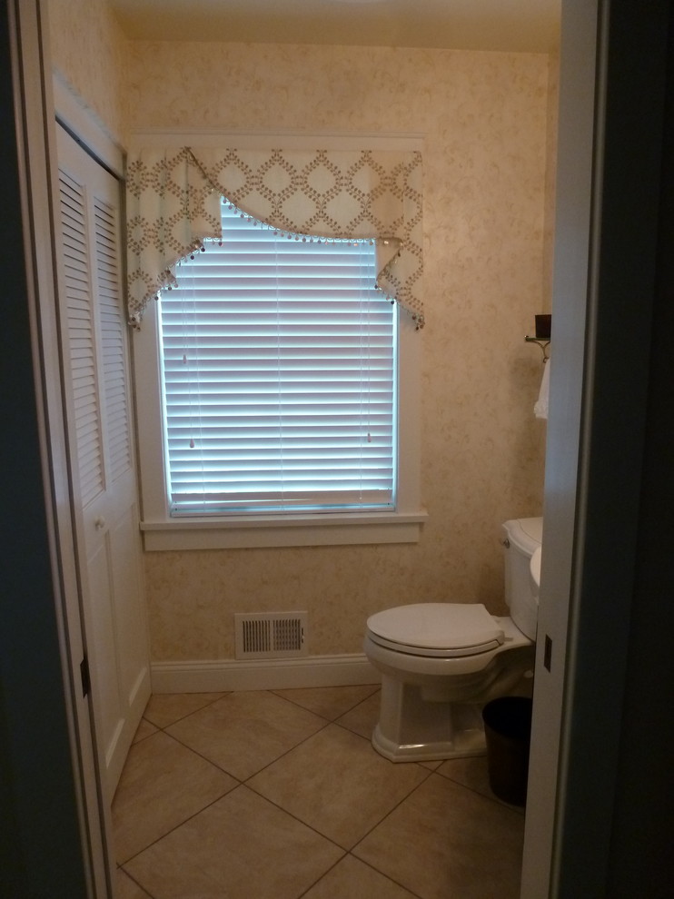 This is an example of a small traditional powder room in Philadelphia with a two-piece toilet, beige tile and beige walls.