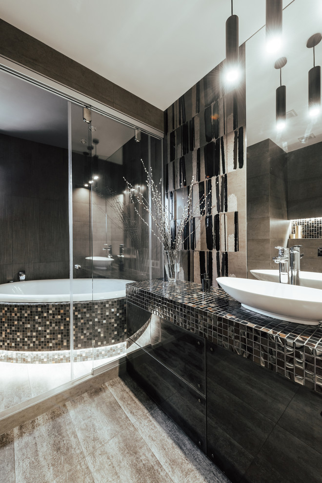Photo of a contemporary master bathroom in Other with flat-panel cabinets, black cabinets, black tile, a vessel sink, tile benchtops, beige floor and black benchtops.
