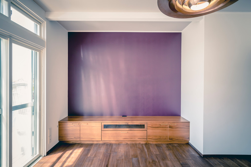 Photo of a mid-sized scandinavian open concept family room in Other with a music area, purple walls, dark hardwood floors, no fireplace, a freestanding tv and brown floor.