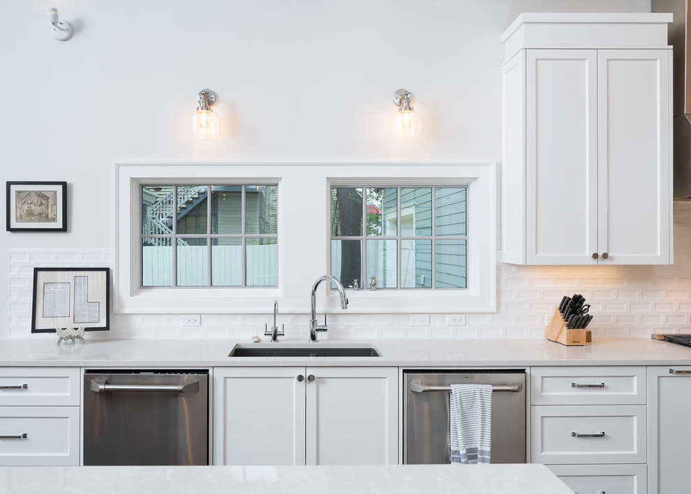 Mid-sized transitional u-shaped dark wood floor and brown floor open concept kitchen photo with an undermount sink, shaker cabinets, white cabinets, quartz countertops, white backsplash, ceramic backsplash, stainless steel appliances and an island