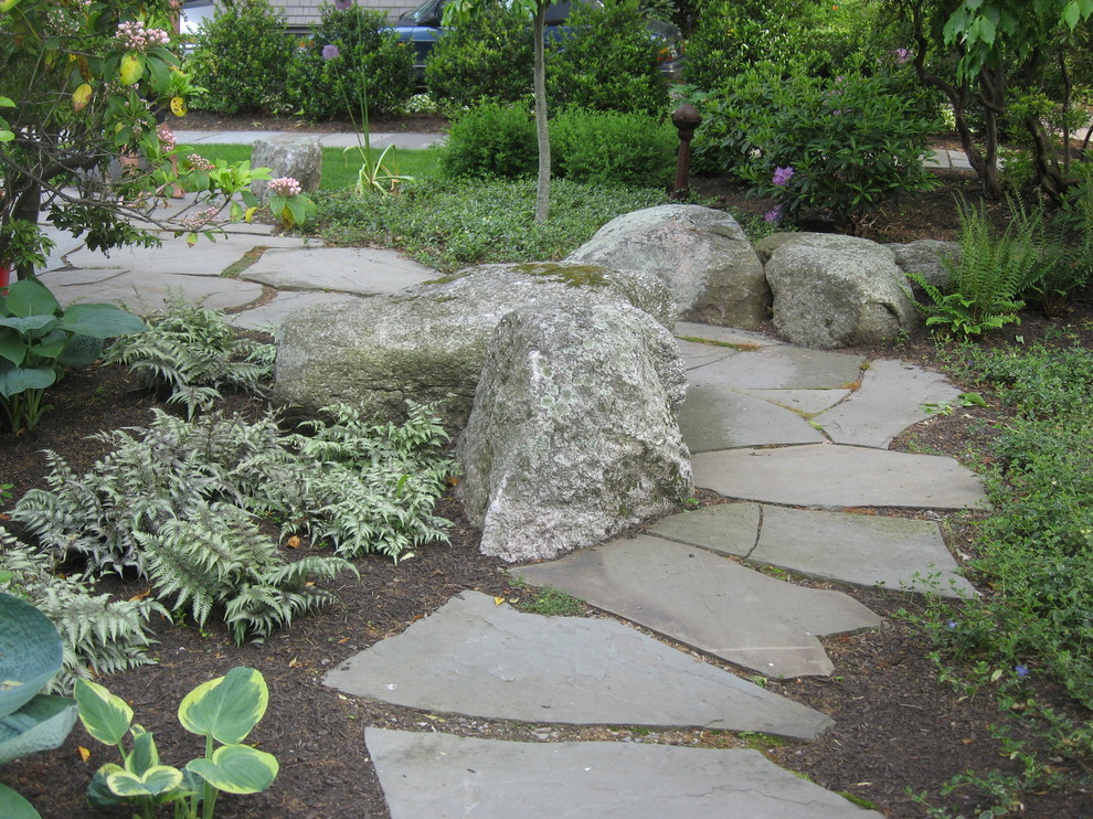This is an example of a mid-sized traditional side yard shaded garden for summer in Boston with natural stone pavers.