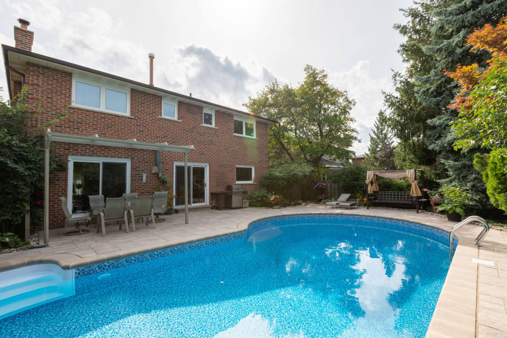 Idee per una piscina minimalista a "C" di medie dimensioni e dietro casa con paesaggistica bordo piscina e pavimentazioni in cemento