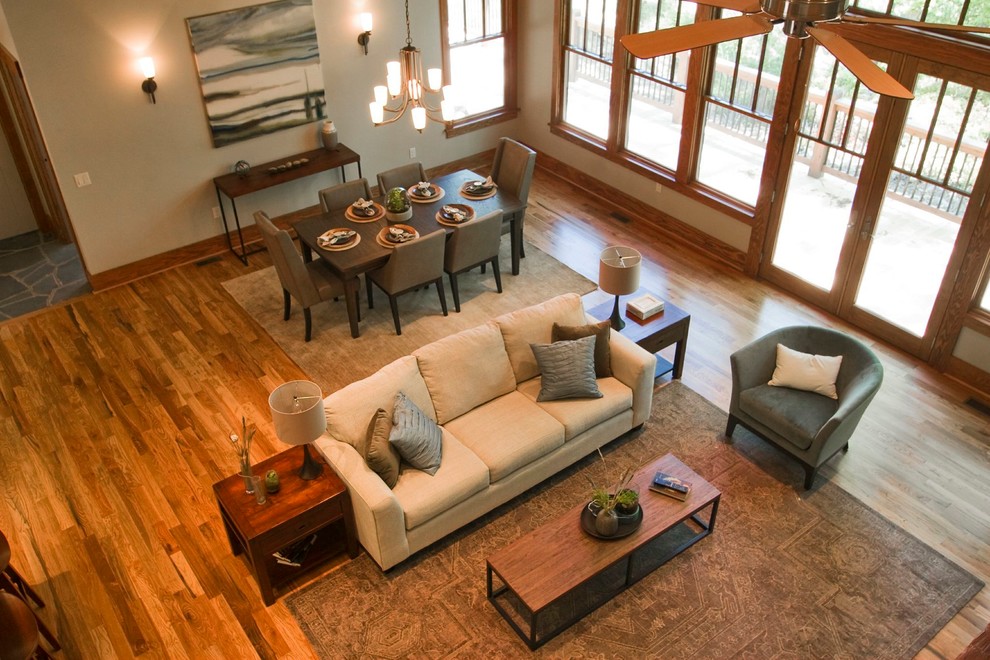 This is an example of a mid-sized arts and crafts open concept living room in Other with beige walls, medium hardwood floors, a standard fireplace and a stone fireplace surround.