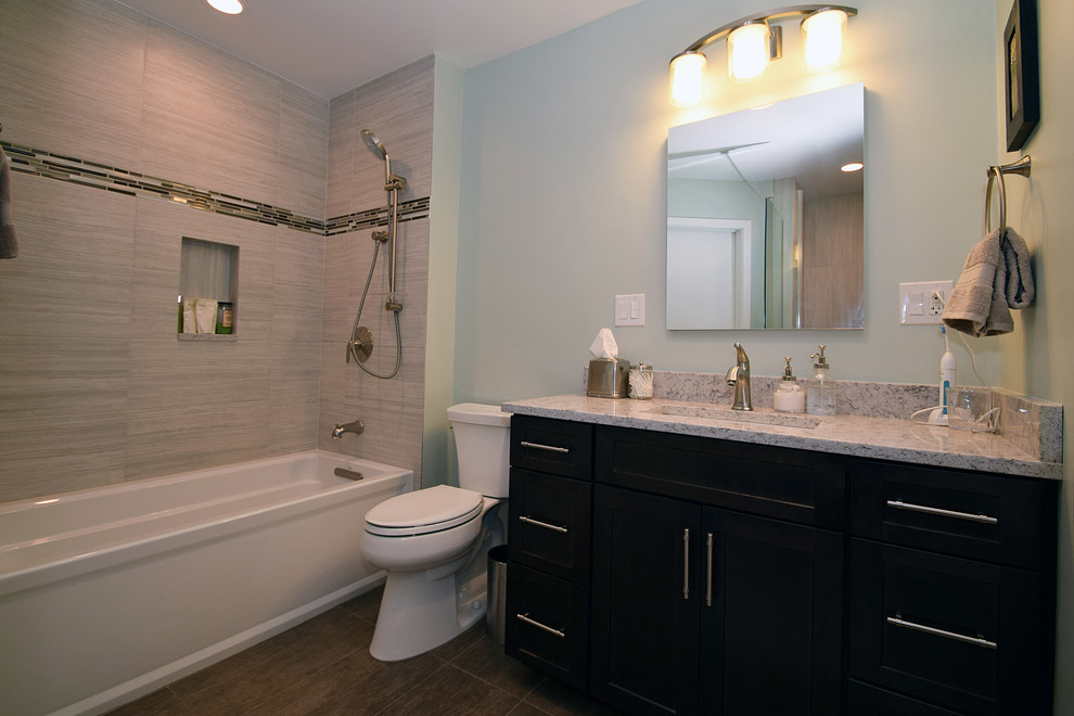 Photo of a mid-sized transitional master bathroom in Chicago with an undermount sink, shaker cabinets, dark wood cabinets, engineered quartz benchtops, an alcove tub, a corner shower, a two-piece toilet, gray tile, porcelain tile, green walls, porcelain floors and brown floor.