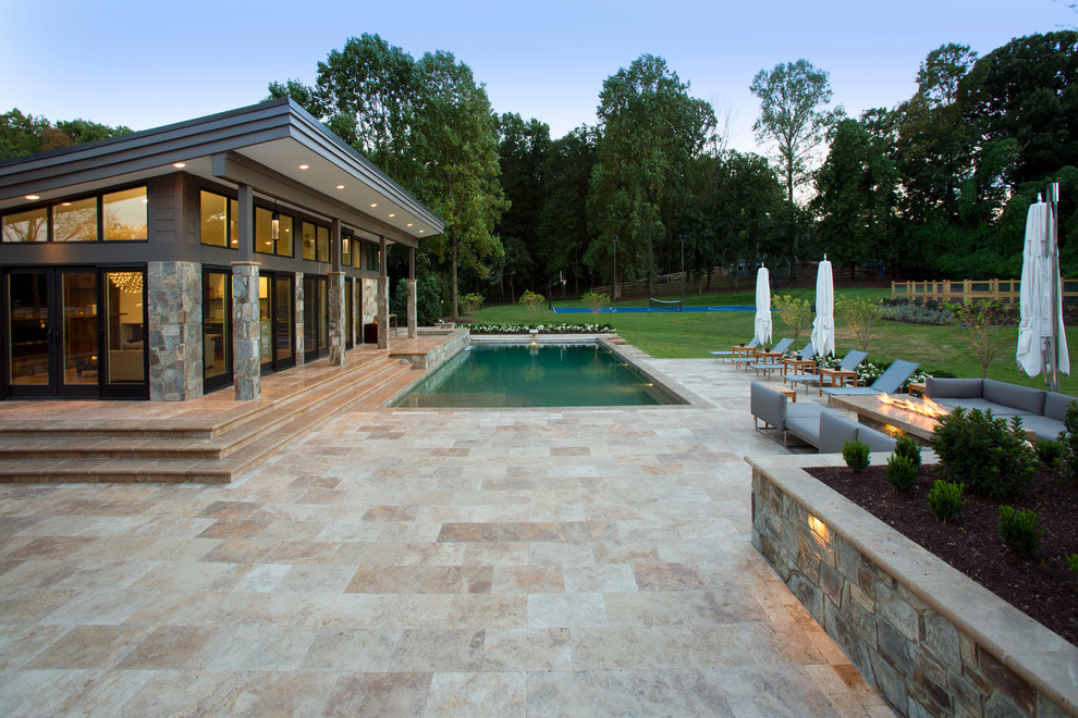 This is an example of a large traditional backyard pool in DC Metro with natural stone pavers.
