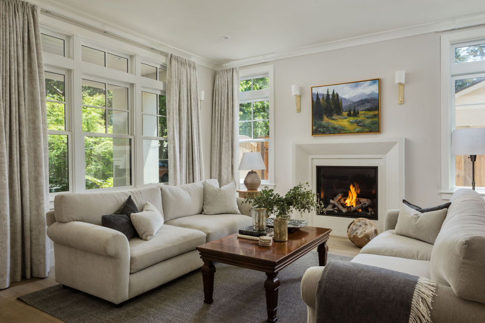 Design ideas for a mid-sized transitional formal open concept living room in San Francisco with white walls, medium hardwood floors, a standard fireplace, a plaster fireplace surround, no tv and grey floor.