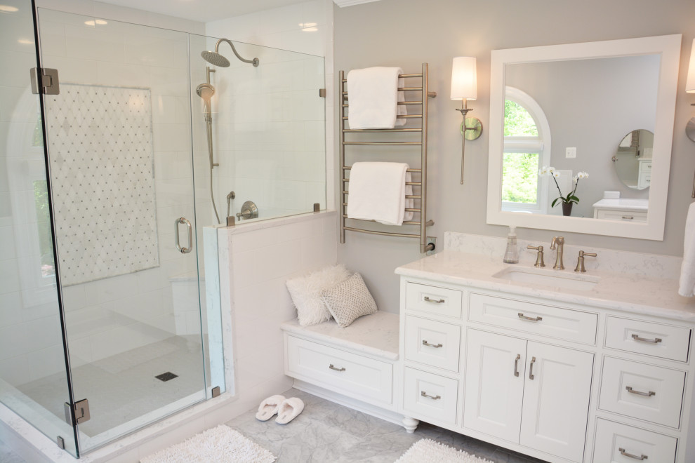 This is an example of a large romantic ensuite bathroom in Baltimore with recessed-panel cabinets, white cabinets, a freestanding bath, an alcove shower, a two-piece toilet, white tiles, grey walls, a submerged sink, engineered stone worktops, grey floors, a hinged door, white worktops, a shower bench, double sinks and a freestanding vanity unit.