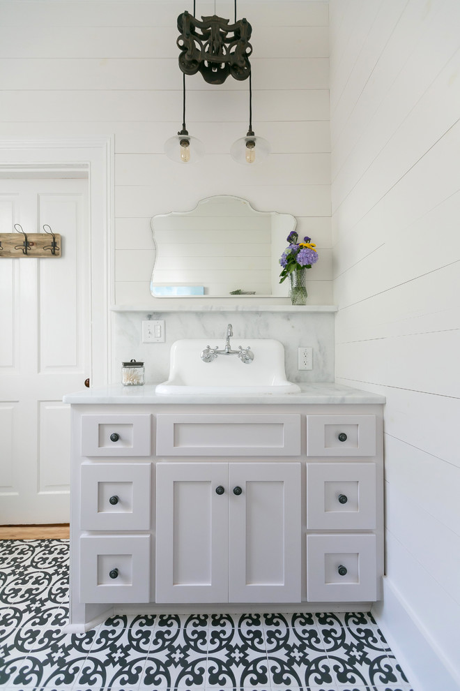 Design ideas for a mid-sized arts and crafts bathroom in Charleston with shaker cabinets, white cabinets, a corner shower, a one-piece toilet, black and white tile, white walls and an undermount sink.