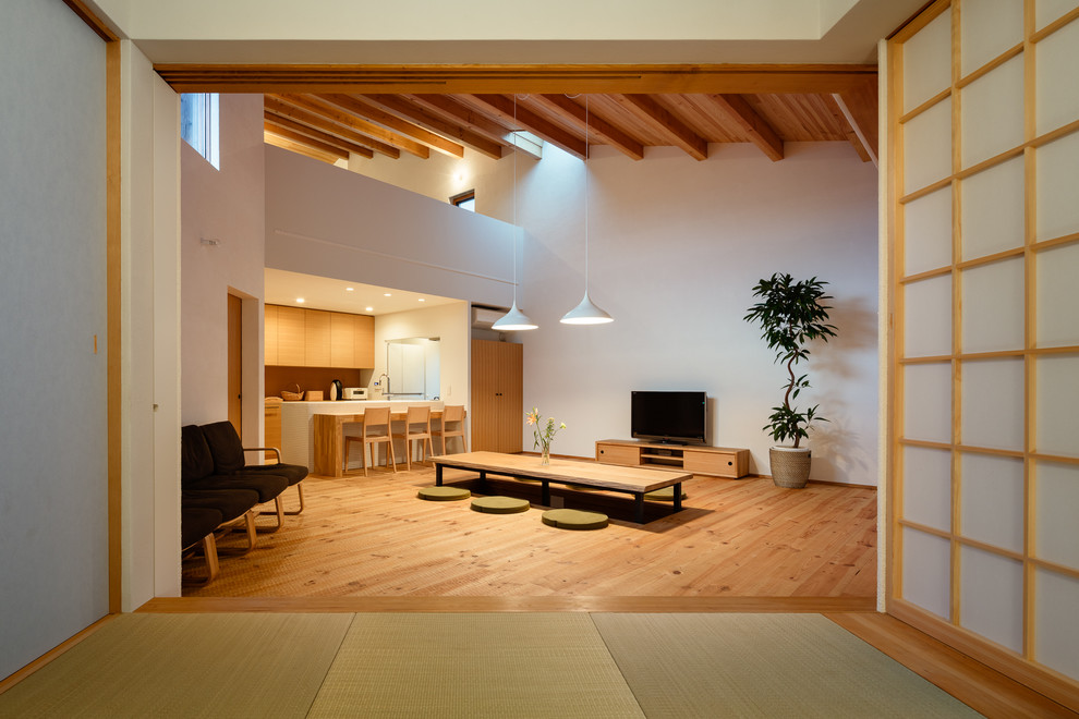 This is an example of a beach style family room in Other with white walls, tatami floors and green floor.